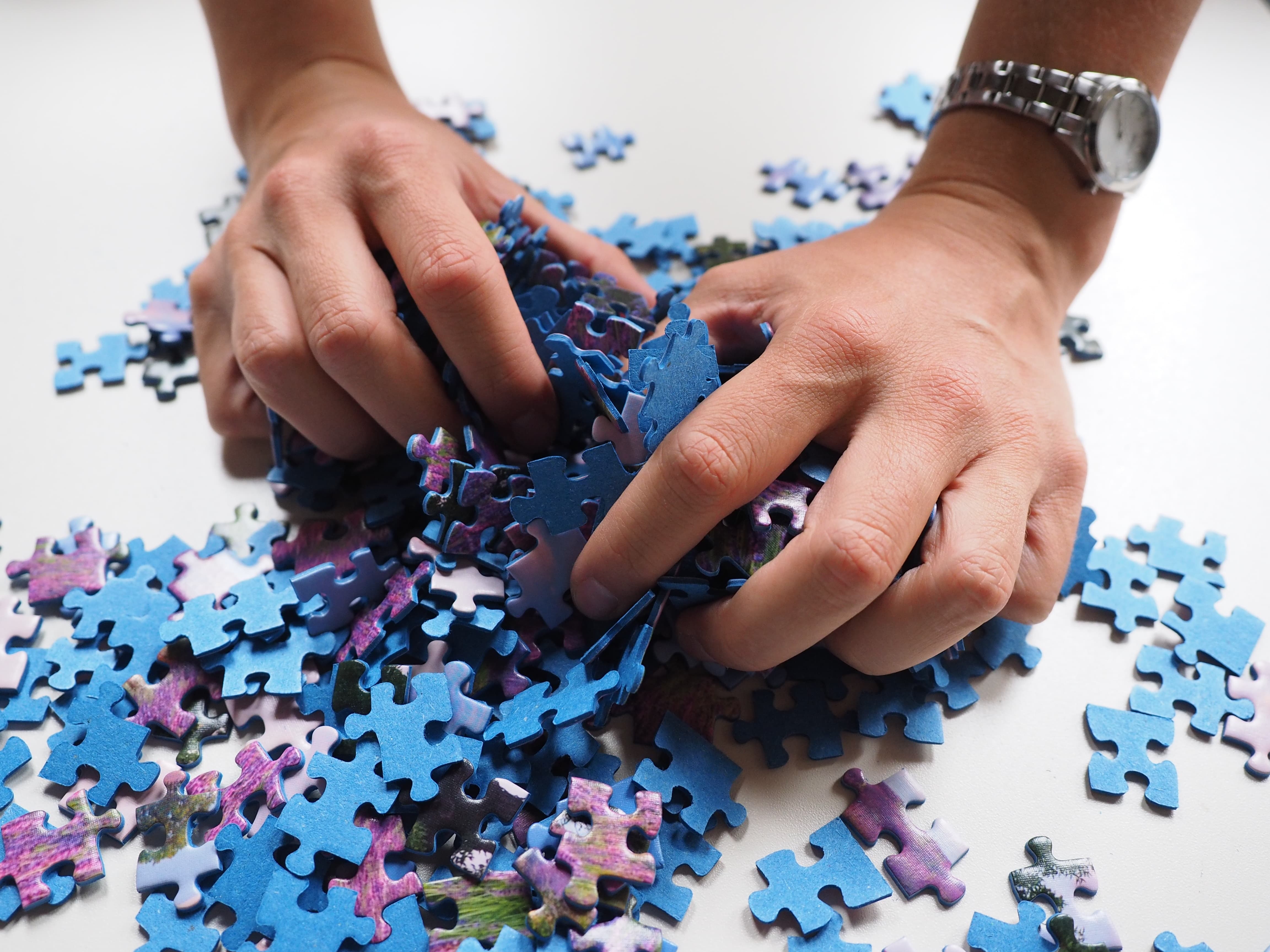 Hands Spreading Puzzle Pieces